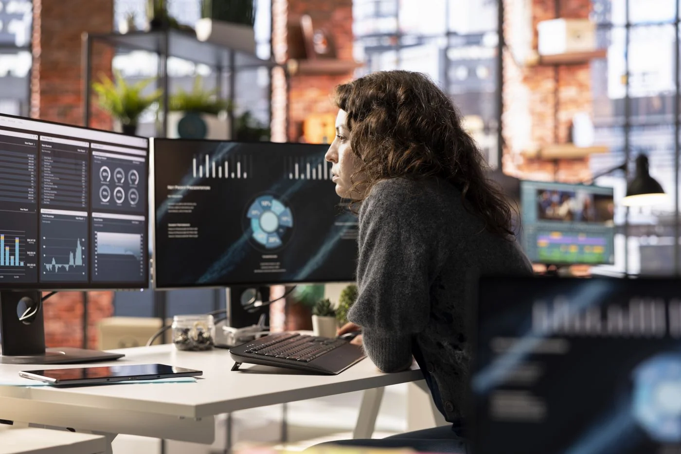 A supply planner reviewing planning dashboards across several screens