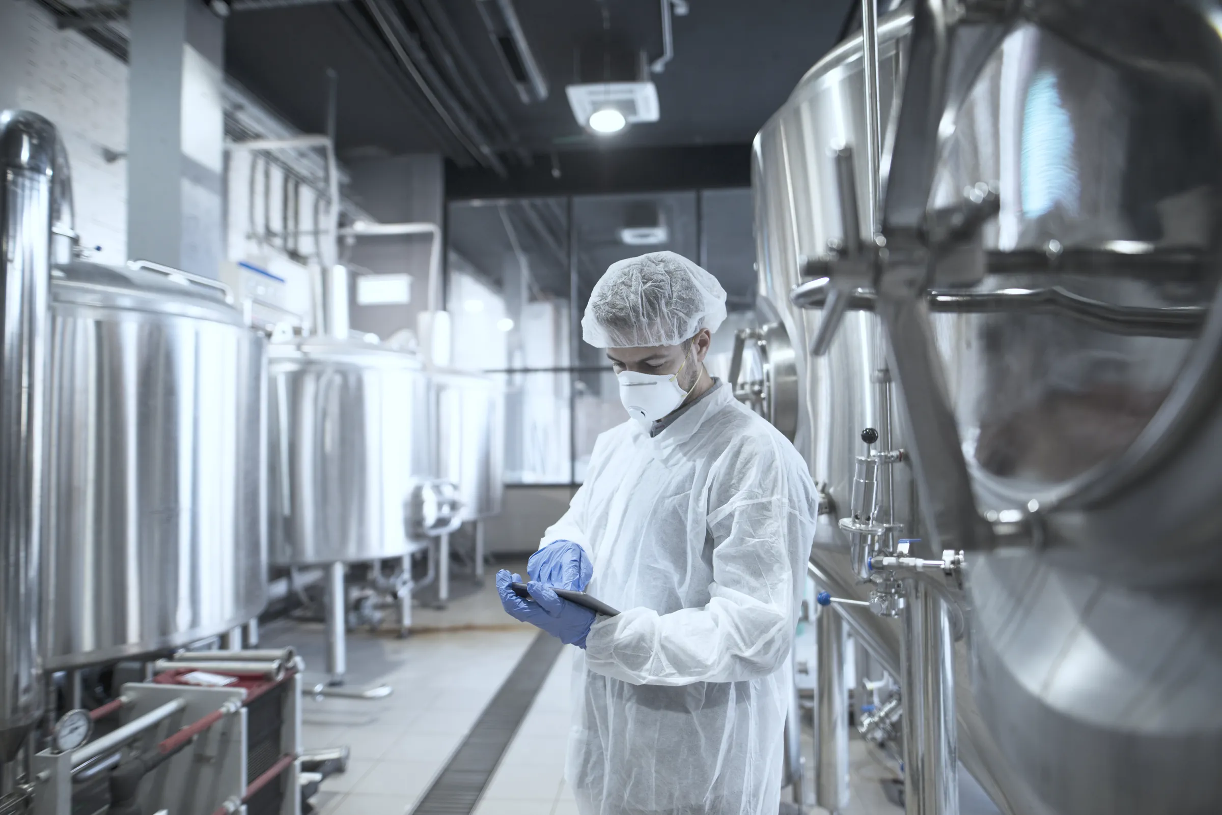 An operator checking production equipment on a manufacturing floor